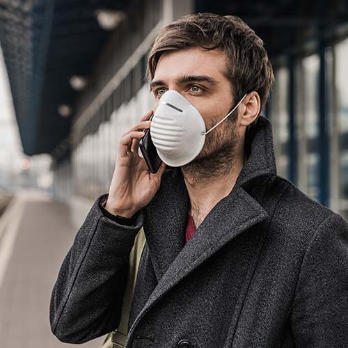 Telefonierender Mann mit Mundschutzmaske